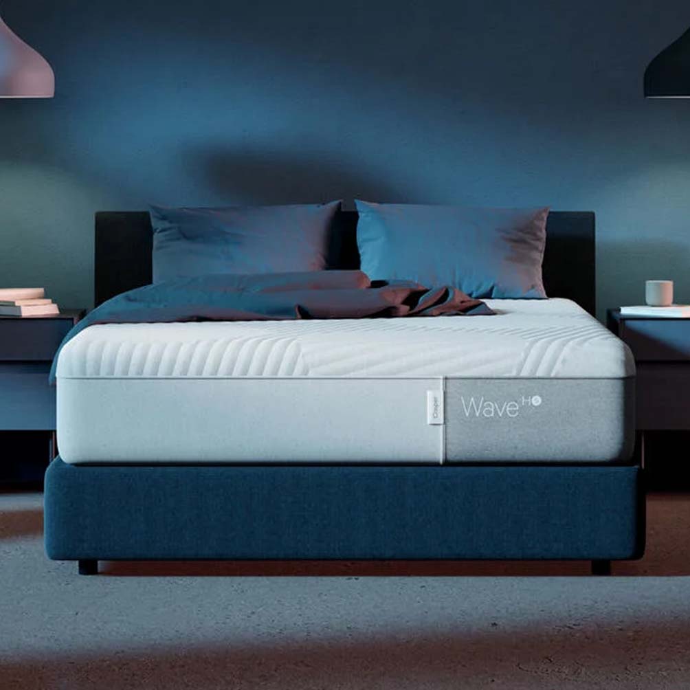 Wave Hybrid Snow Mattress on blue bed frame with two pillows 