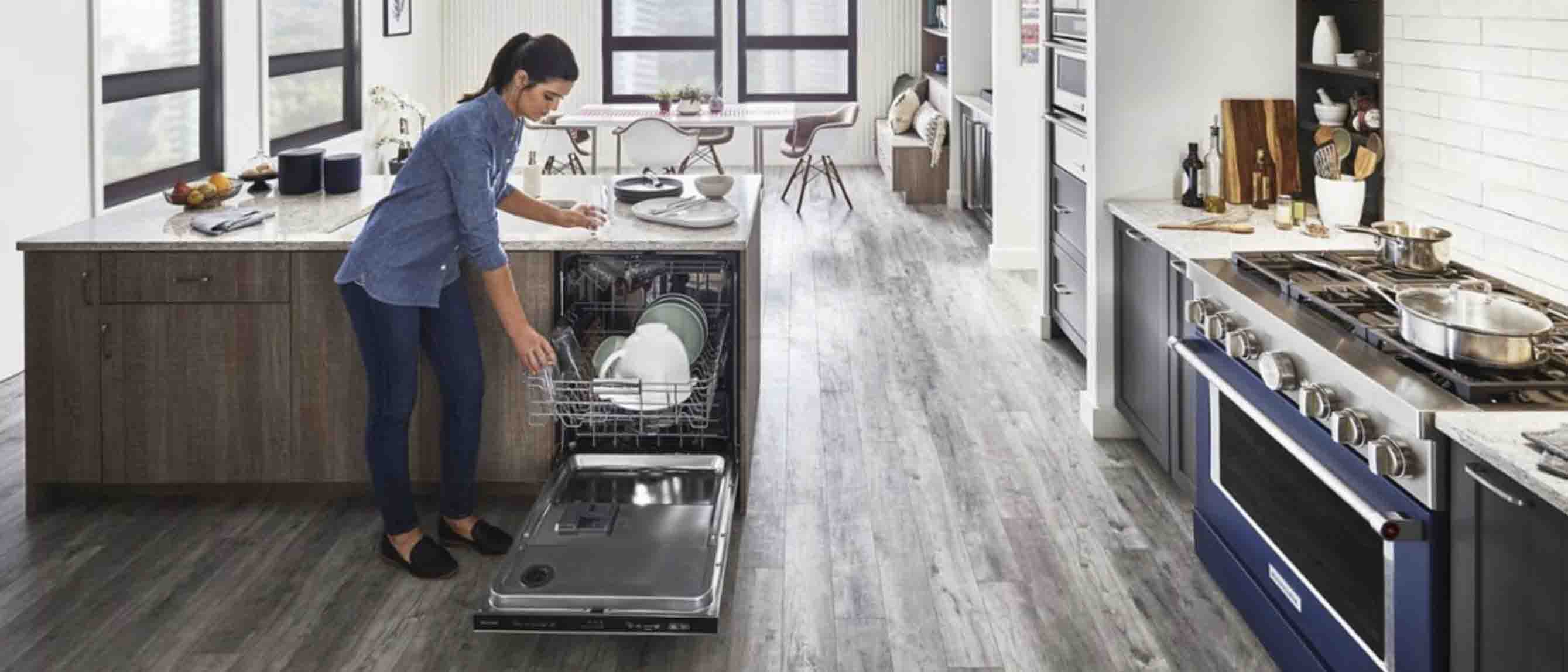 Woman loading dishwasher in home kitchen