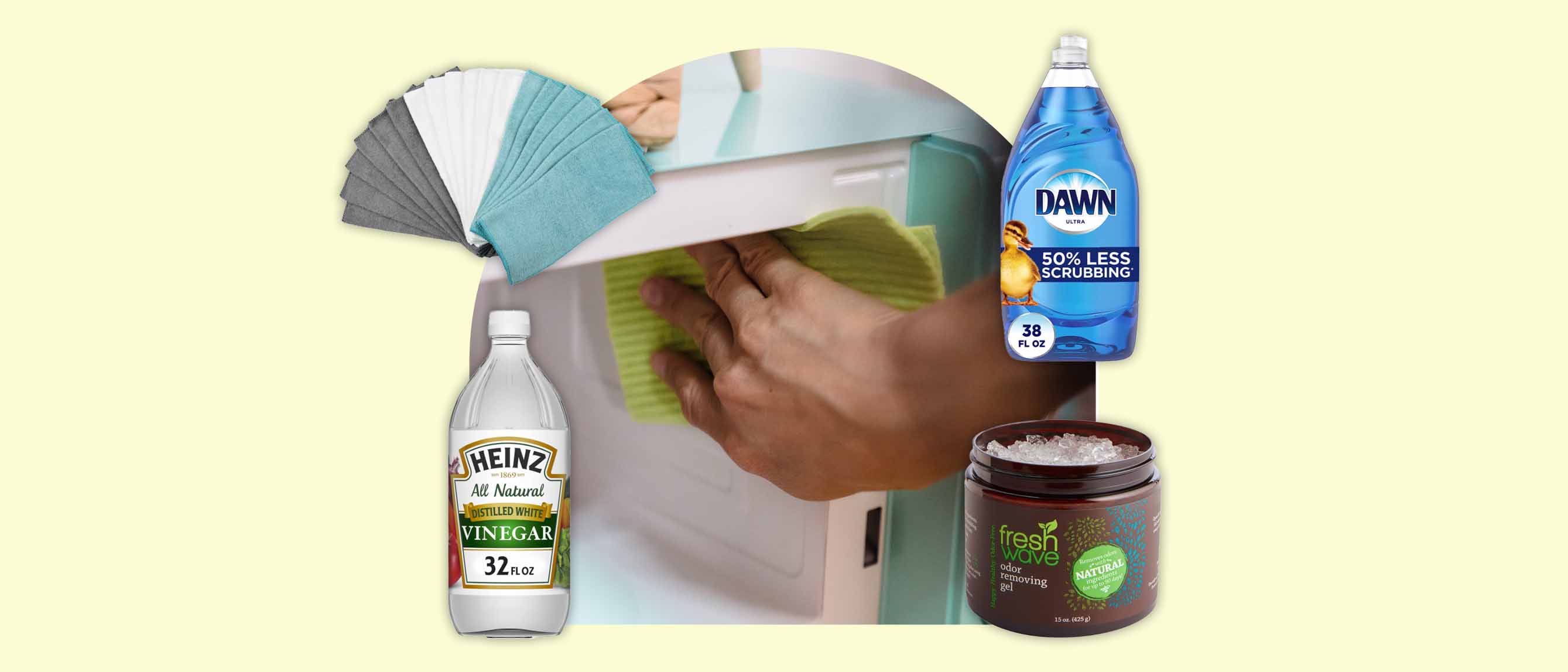 hand wiping the inside of a microwave with a cloth surrounded by cleaning cloths, image white vinegar, dawn liquid soap and odor-removing gel