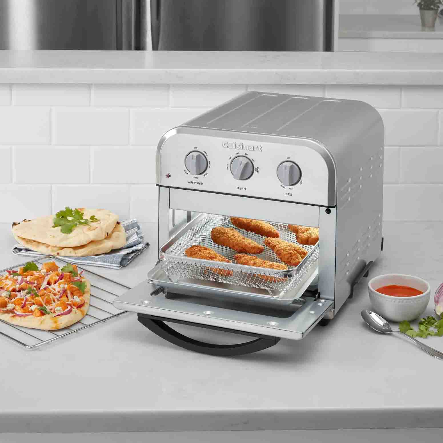 Silver air fryer on countertop with prepared food