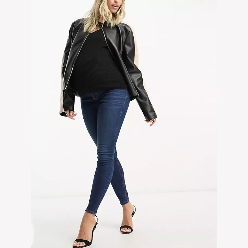 Model wearing dark blue skinny maternity jeans