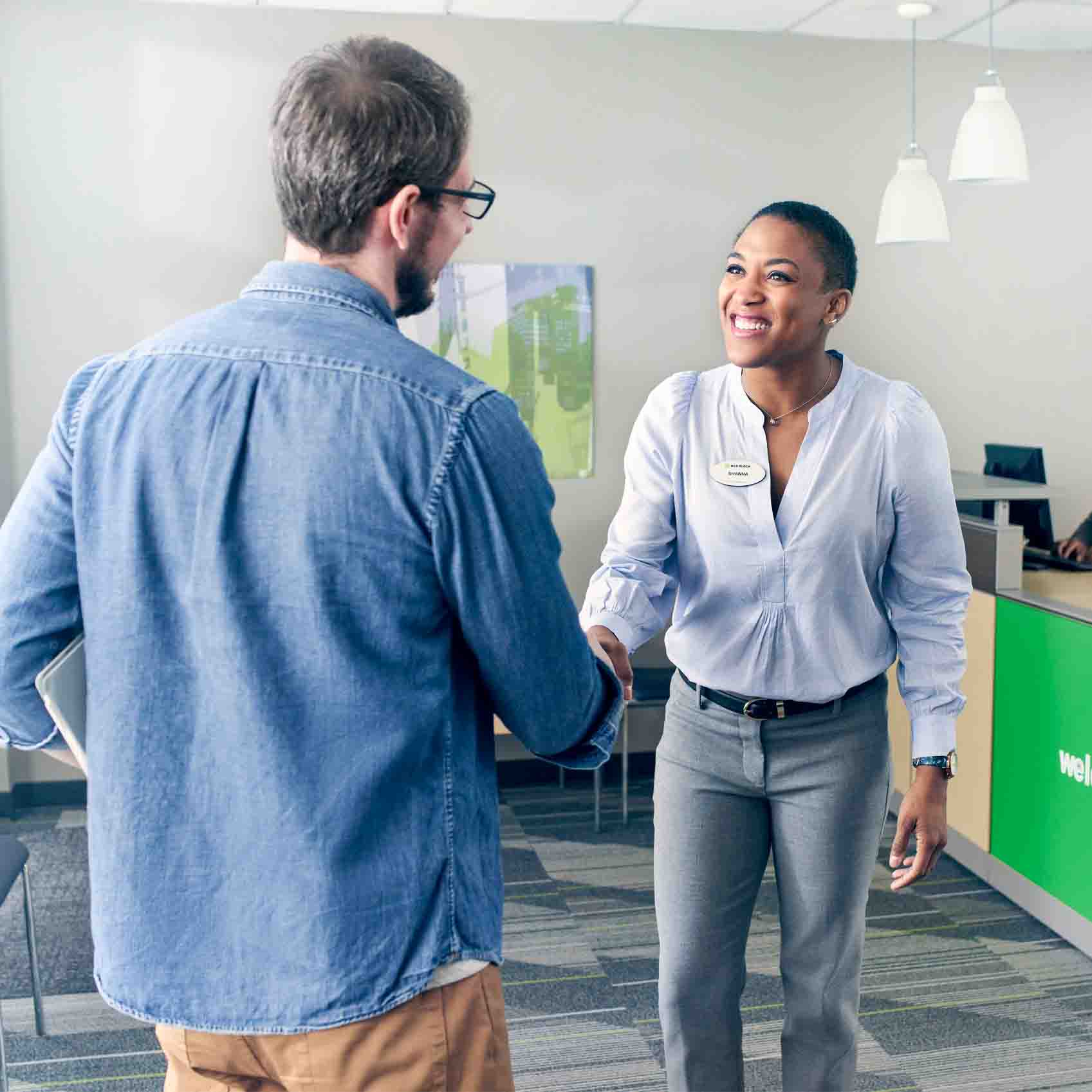 tax advisor greeting a client at the H&R Block office