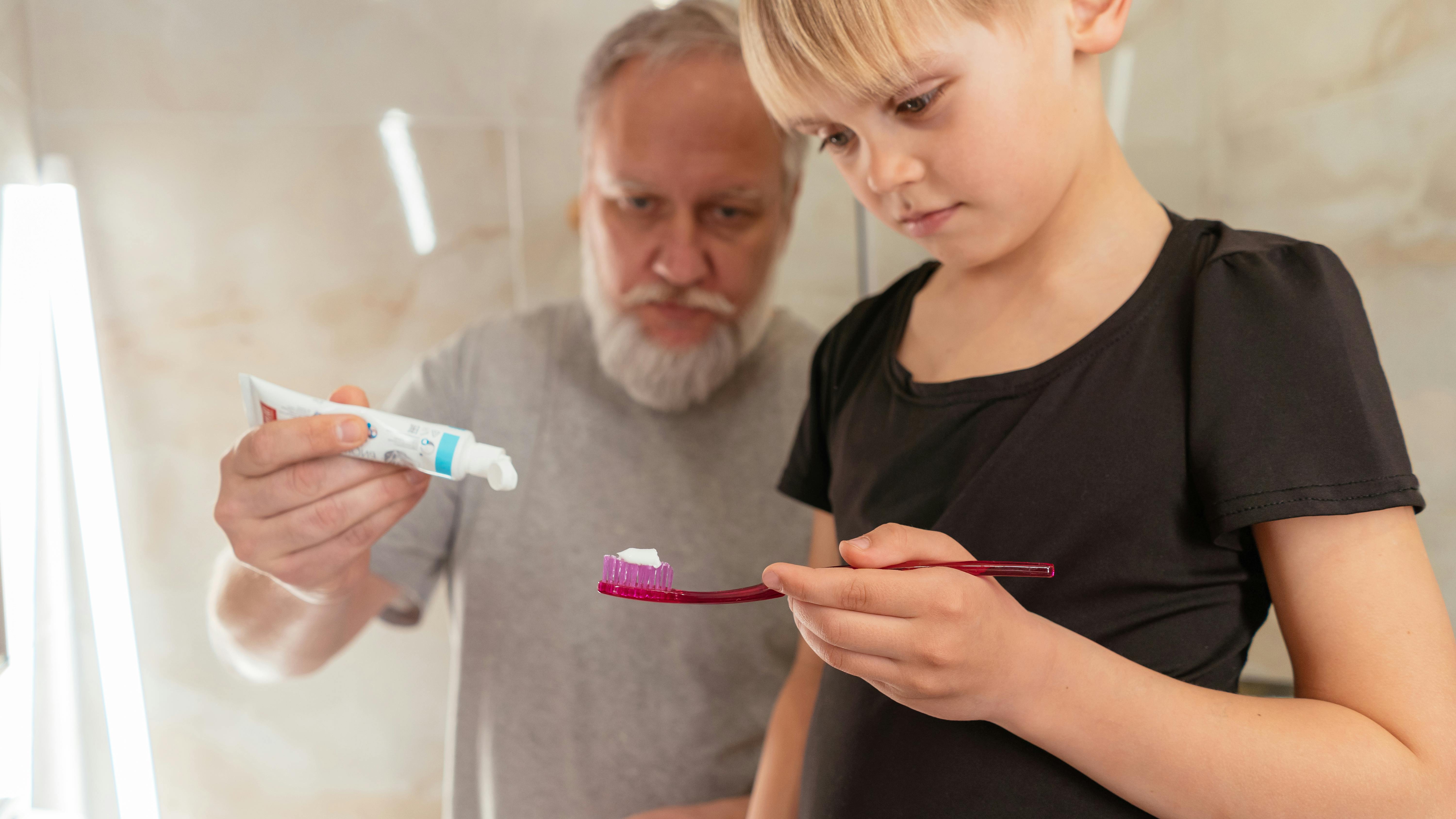 Grandpa putting toothpaste for kid