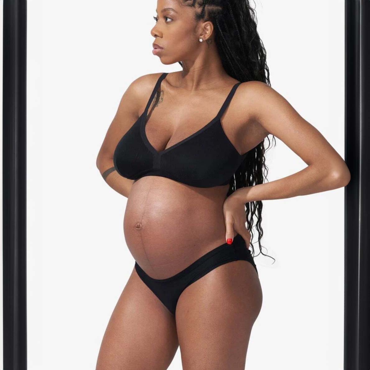 Pregnant woman wearing black bra and underwear