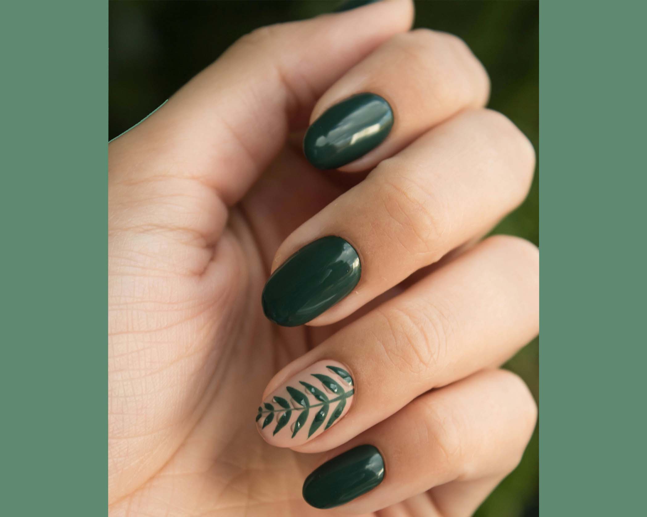 close up shot of a model's hand with green nails with a leaf design
