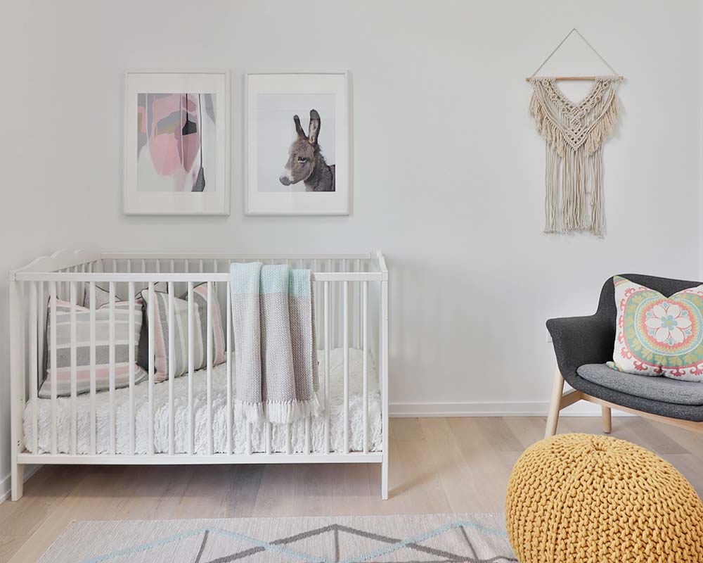 baby nursery with a crib, armchair and pouffe