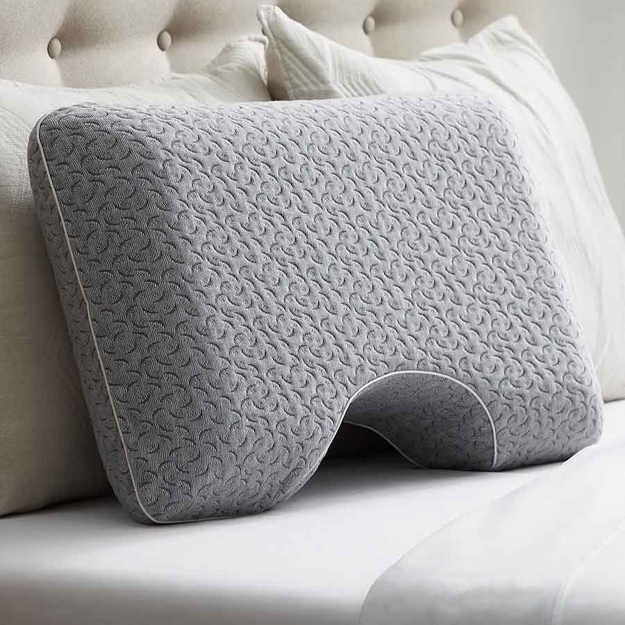 the Allswell Side Sleeper Memory Foam Pillow in grey against a white headboard