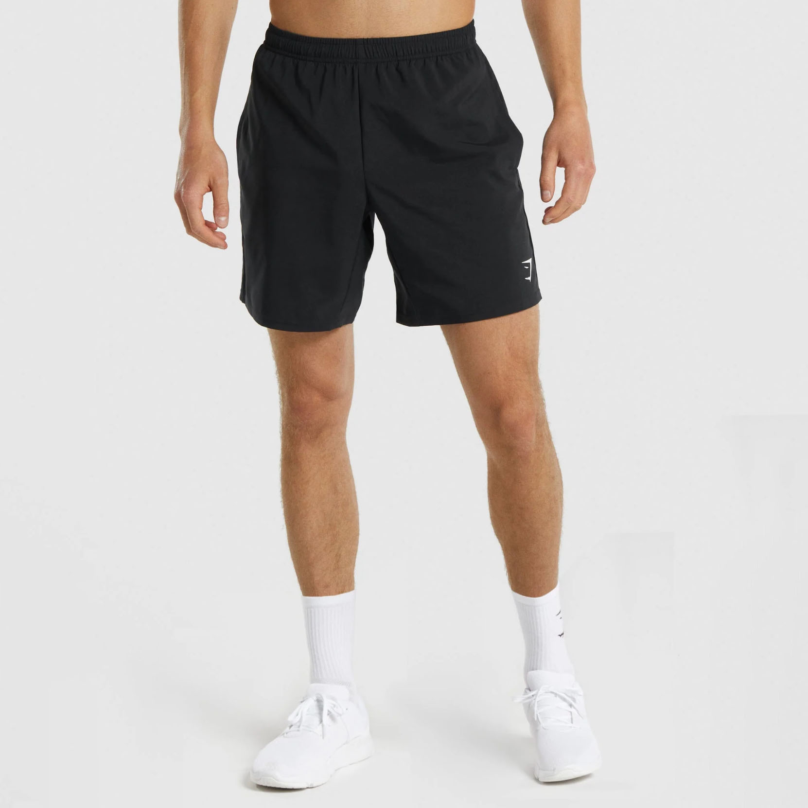 Shirtless man wearing black Gymshark shorts