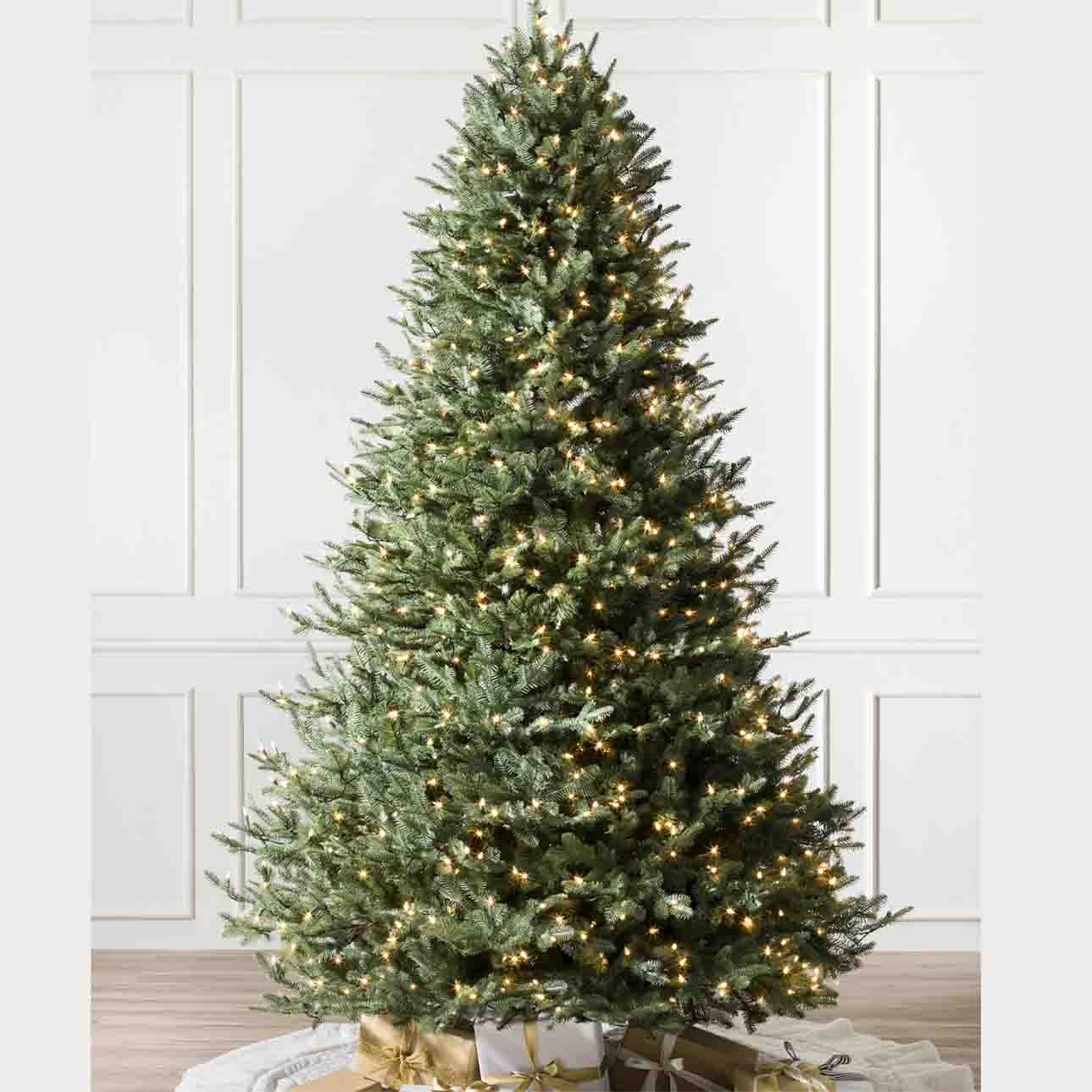a 7.5ft green artificial BH Balsam Fir Tree with LED lights with gifts under the tree