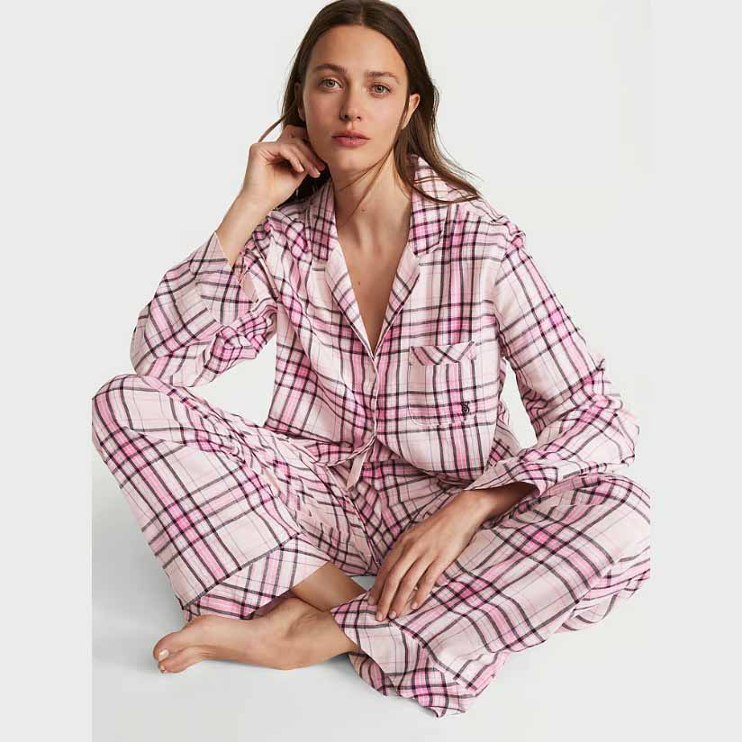 Model seated wearing pink and white flannel long pajama set