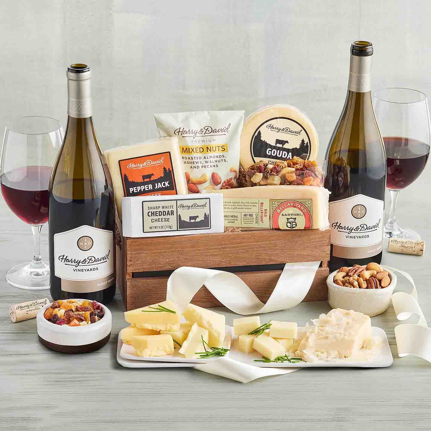 Gourmet Cheese Gift basket with two bottles of wine, packet of mixed nuts, banana chips