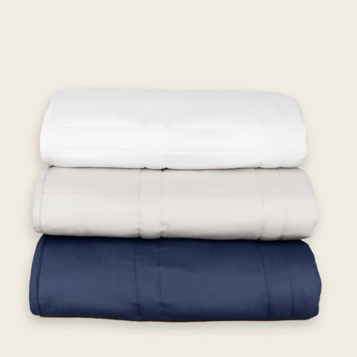 Stack of 3 weighted blankets in navy, beige and white