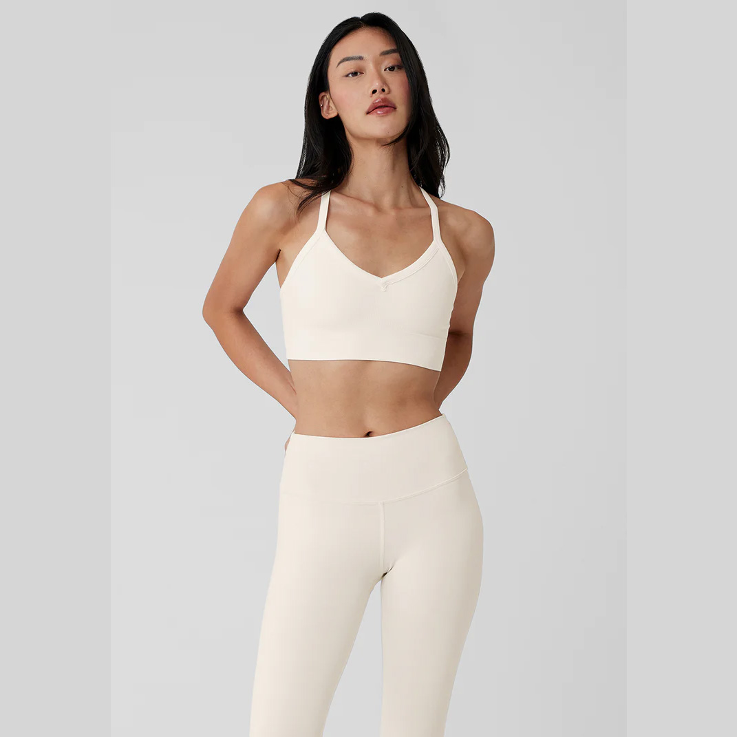 girl wearing Alo Yoga Seamless RIbbed Low Back Bra in ivory with matching leggings