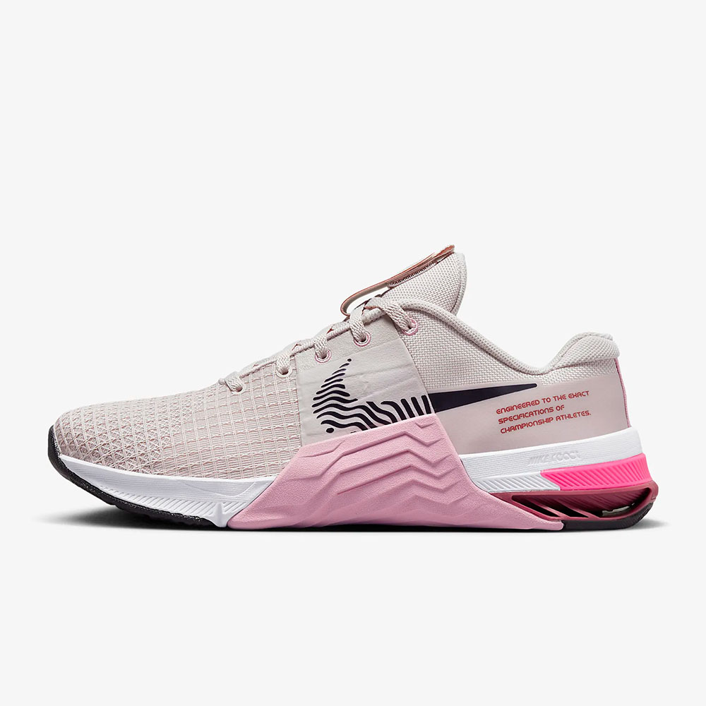 the Nike Metcon 8 Women’s Training Shoe in pink, beige and white with black Nike logo