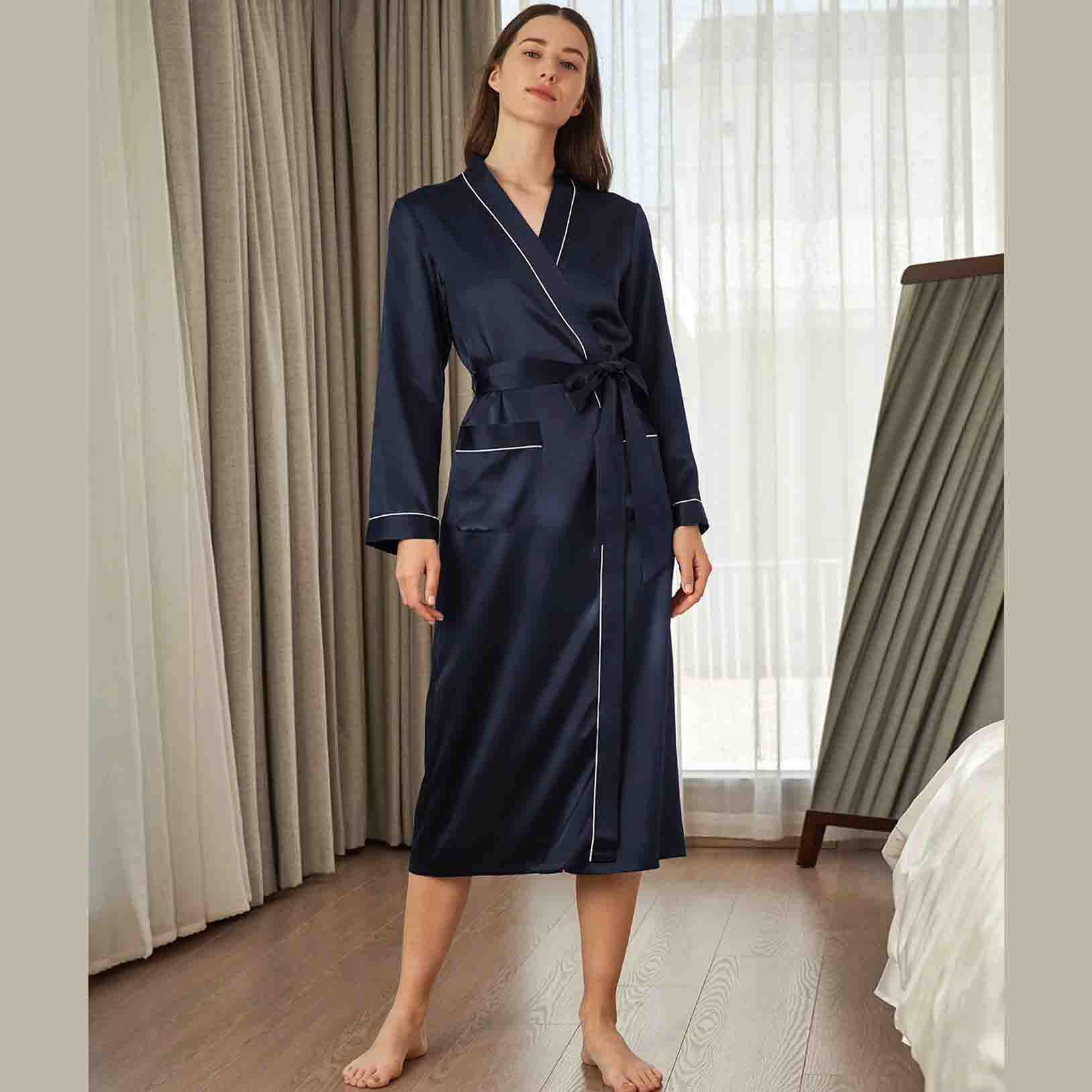 woman wearing a navy full length silk robe with white lining 