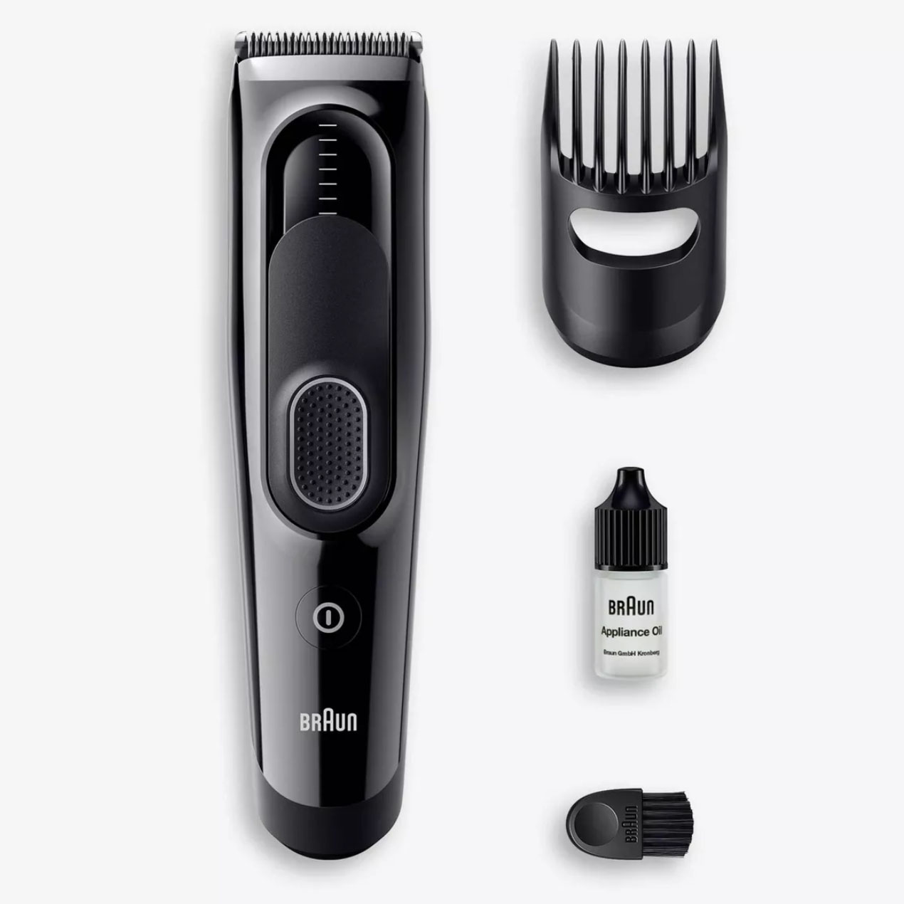 Black cordless clipper with different clipper heads and oil