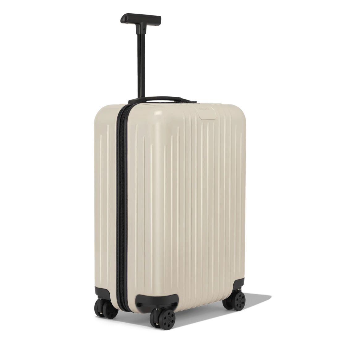 a cream and black hardshell suitcase with a partially extended handle