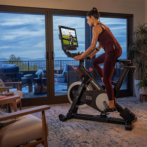 A woman riding a NordicTrack bike in her living room