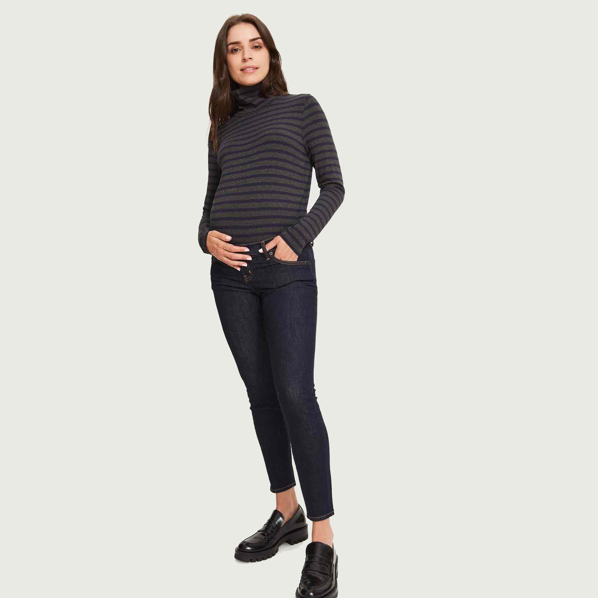 Model in black slim fit maternity jean against a cream background