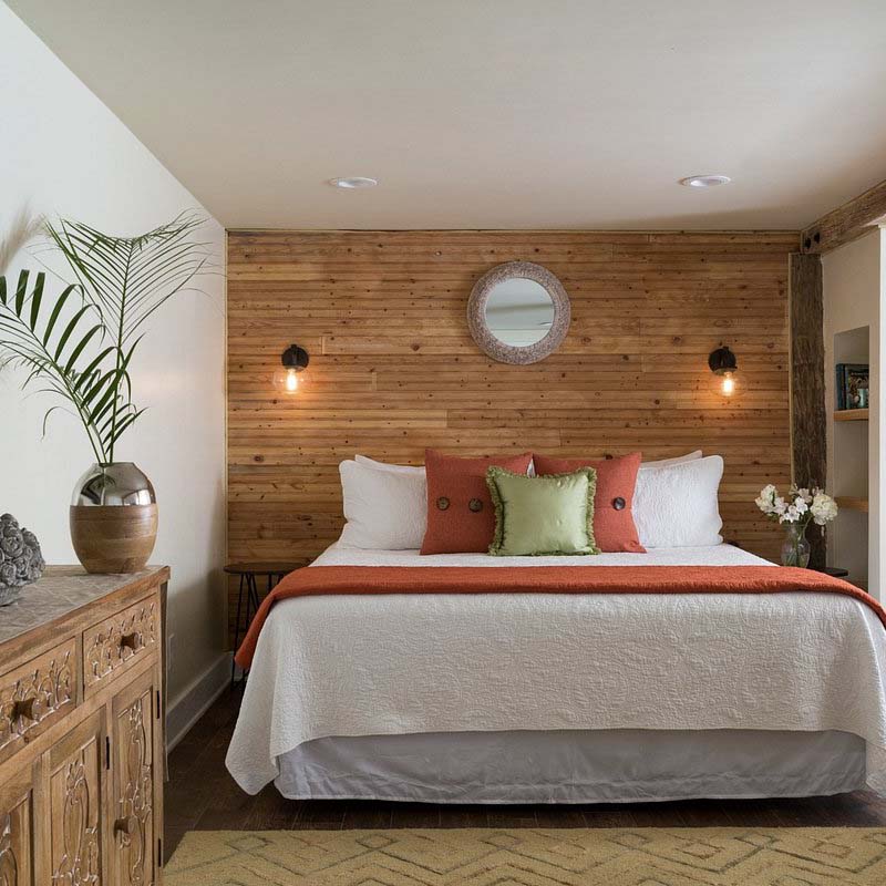 A bedroom in Bayfront Marin house with a wooden feature wall, wooden cabinets and a king size bed