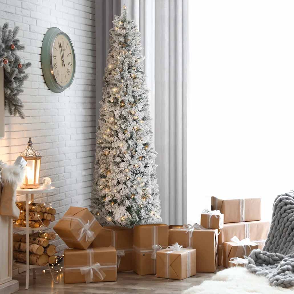 an extra slim artificial pencil tree with lights in a living room surrounded by gifts 