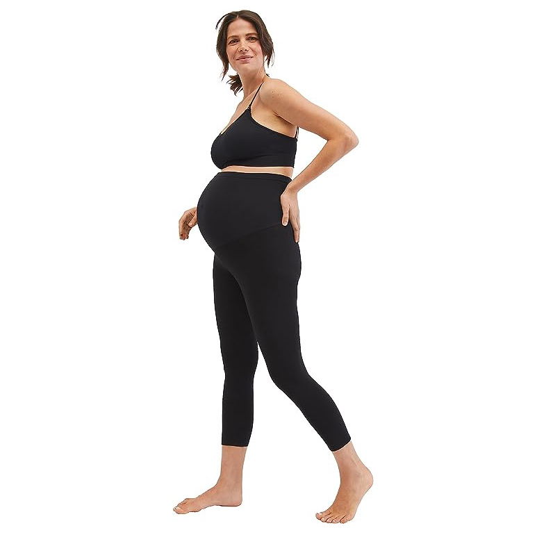side view of pregnant mom in sports bra and black leggings