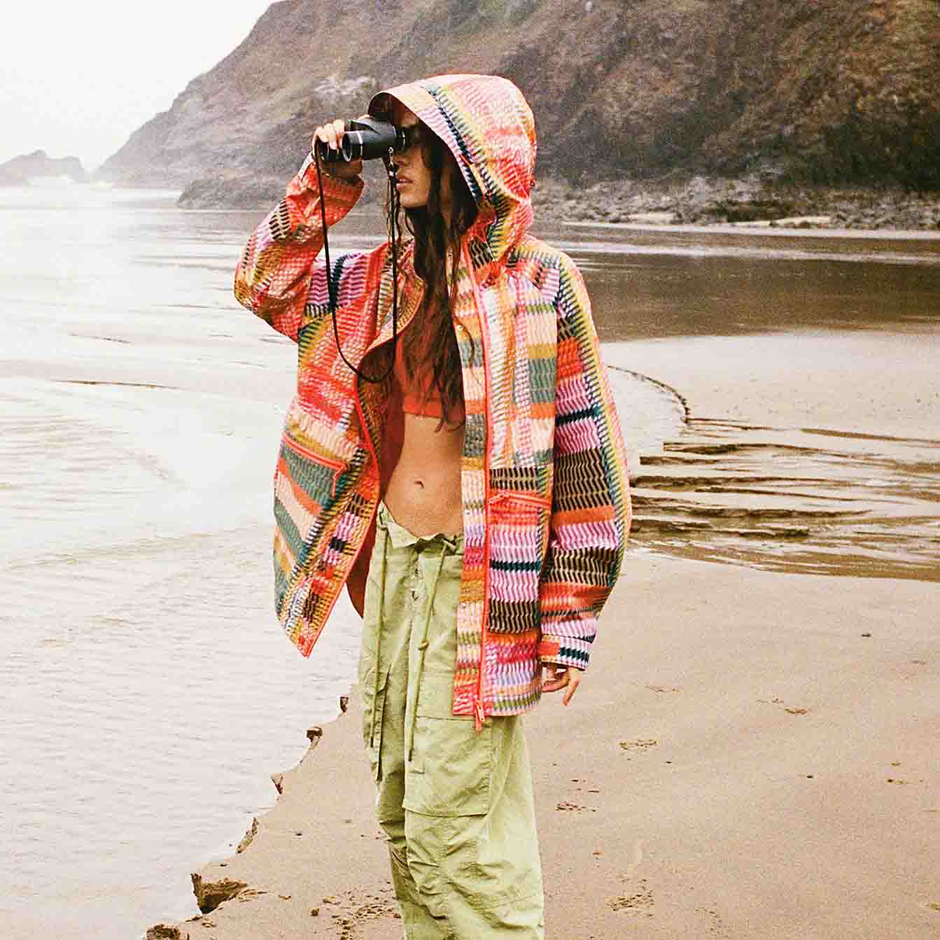 model wearing funky packable jacket on beach
