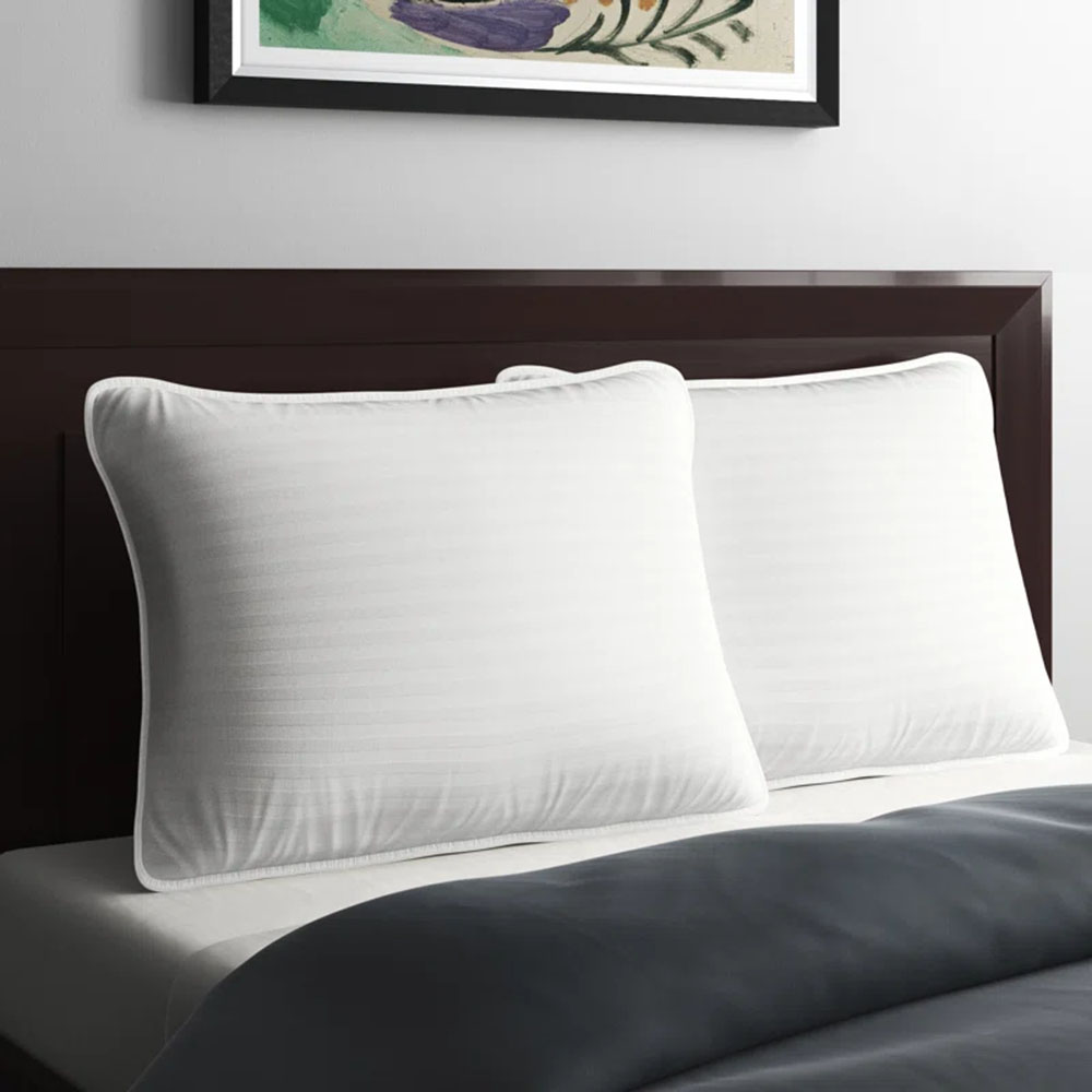 two Cooling Down Alternative Gel Fiber Pillows in white against a black headboard