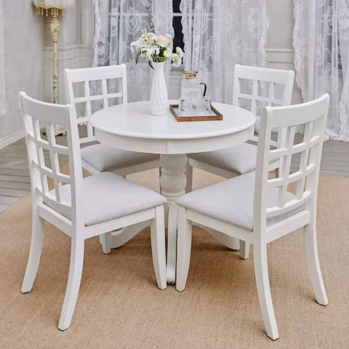 White, round dining table setting with 4 chairs