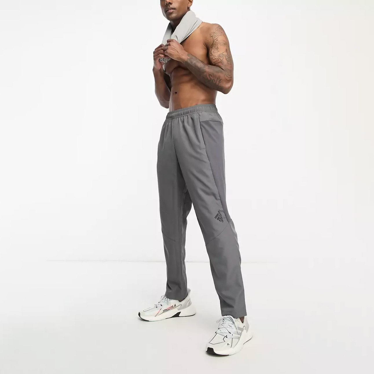 Shirtless man with tattoos wearing grey sweatpants
