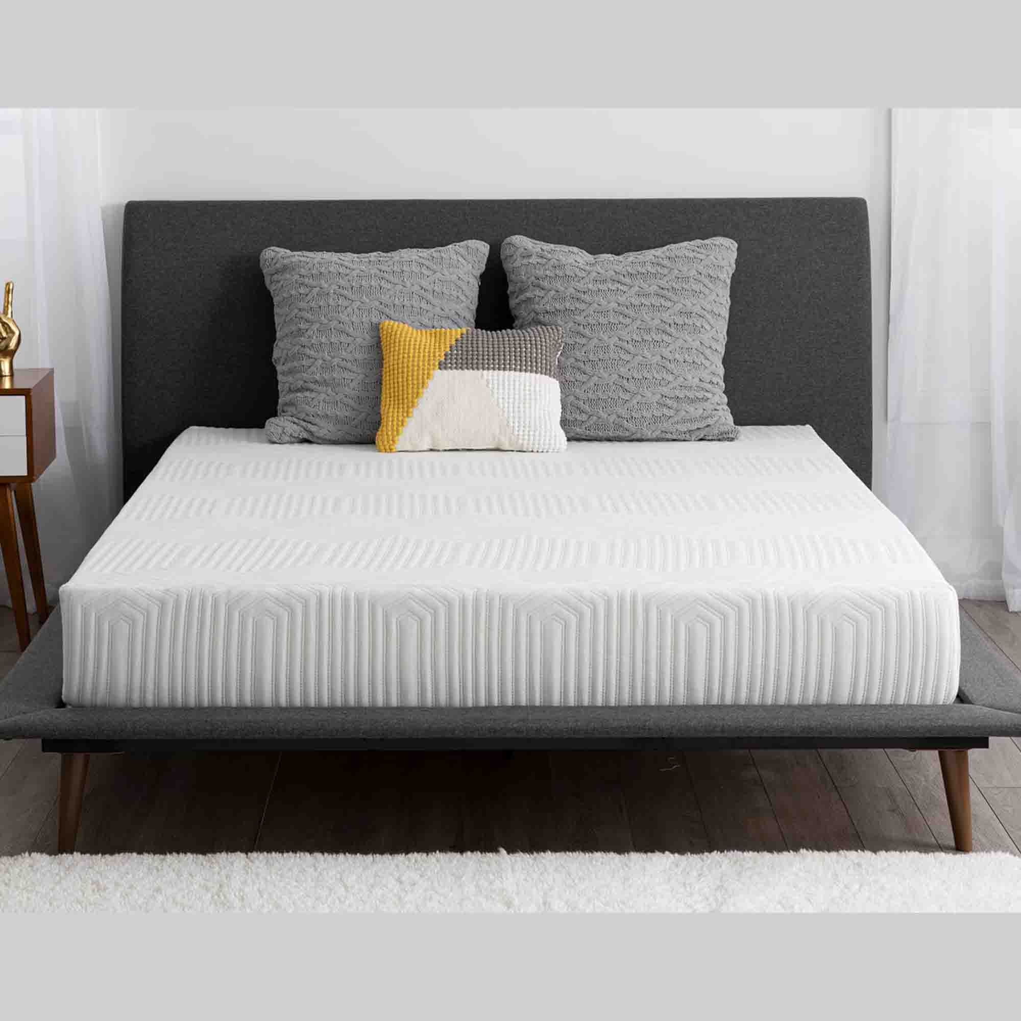 white memory foam mattress with three pillows on a dark grey bed frame