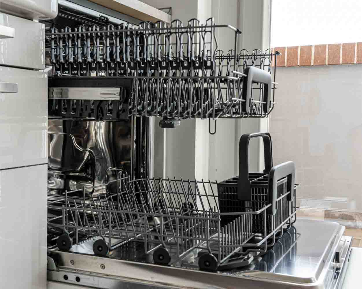 an open and empty rack of a dishwasher in a kitchen