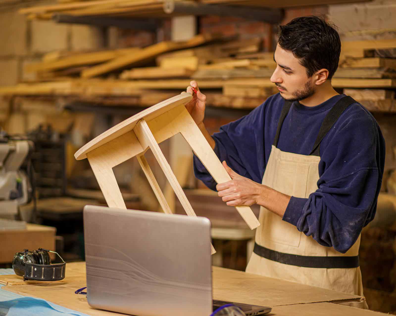 carpenter working on a wooden chair in a workshop