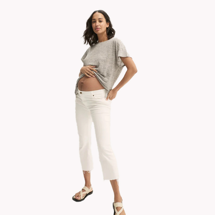 Model wearing white cropped maternity jeans